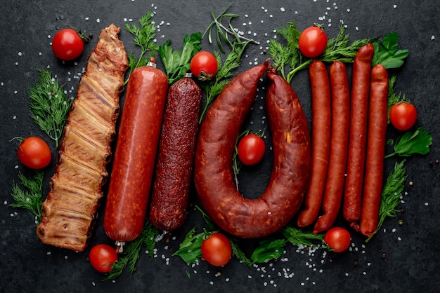 Ensemble de saucisses, salami et viandes fumées au romarin et épices sur une pierre