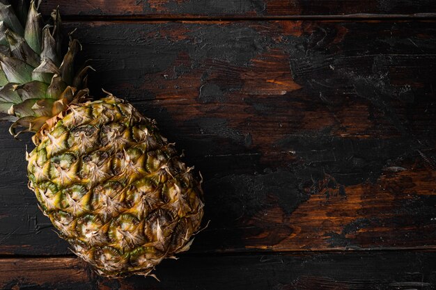 Ensemble savoureux d'ananas entiers, sur fond de table en bois ancien, vue de dessus à plat, avec espace de copie pour le texte