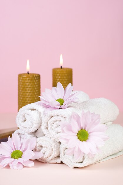 Ensemble de serviettes avec des fleurs pour les soins Spa sur fond rose. Espace copie