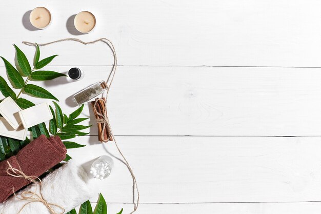 Ensemble spa naturel avec grains de café cannelle sel de mer huile serviette brune noix de coco et feuilles vertes sur la Pentecôte