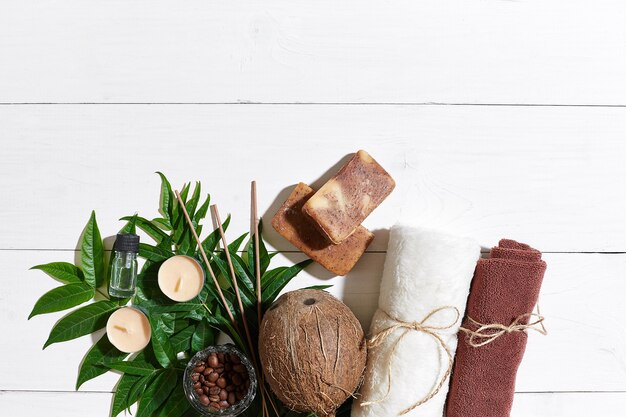 Ensemble De Spa Avec Serviette Et Savon Sur Fond De Bois Blanc Avec Des Feuilles Vertes