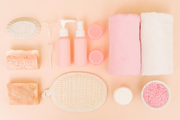 Ensemble de spa de soins du corps Mode de vie relaxant sain Assortiment de produits cosmétiques sur fond rose corail Mise à plat