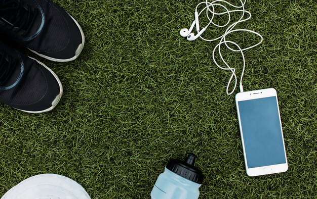 Ensemble de sport garçon ou fille, qui aime courir. Téléphone, casque, chaussures, bouteille d'eau et chips pour courir.