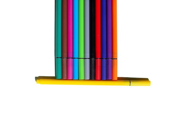 Un ensemble de stylos colorés sur fond blanc Le concept de fournitures scolaires et de travail de bureau