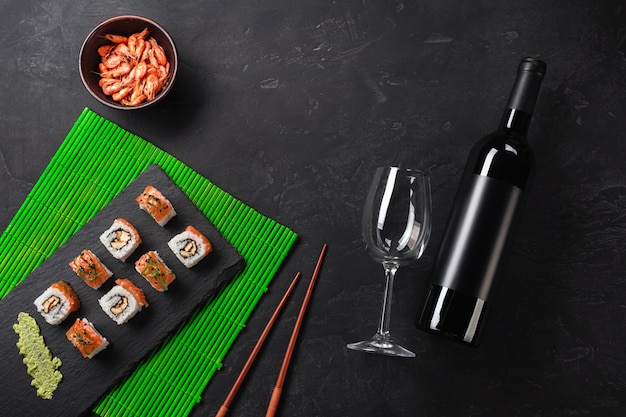 Ensemble de sushi et maki avec une bouteille de vin sur la table en pierre. Vue de dessus avec espace de copie