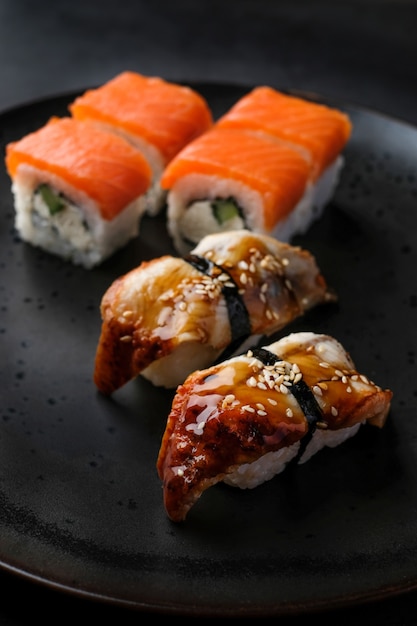 Ensemble de sushis japonais traditionnels avec du poisson rouge au tableau noir