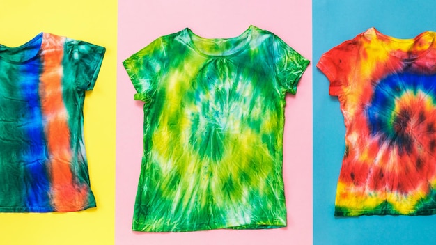 Un ensemble de t-shirts tie dye sur fond multicolore Mise à plat