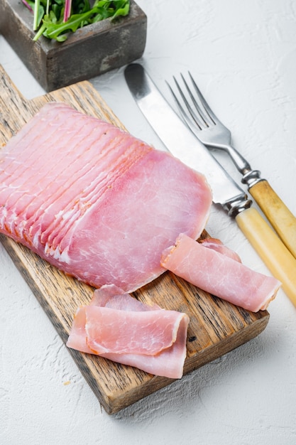 Ensemble de tranches de viande de porc séchée, avec herbes et ingrédients, sur pierre blanche