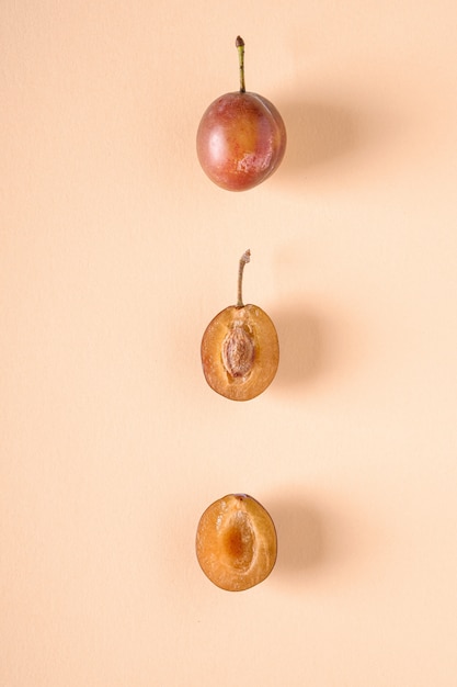 Ensemble de trois fruits de prune douce demi-mûrs en tranches avec des gouttes d'eau