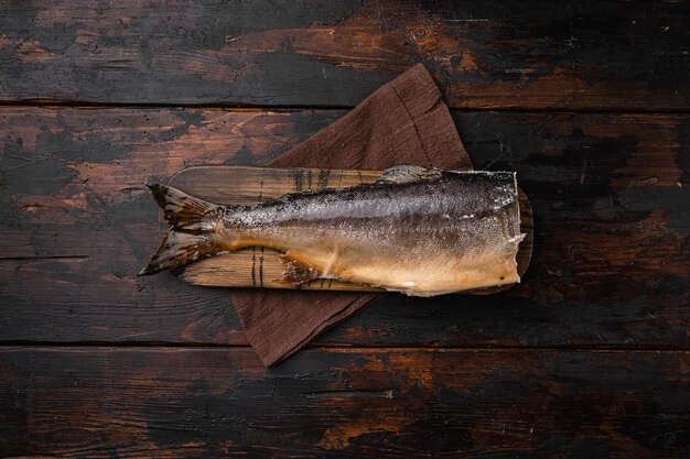 Ensemble de truite ou de saumon fumé à froid, sur un vieux fond de table en bois foncé, vue de dessus à plat, avec espace de copie pour le texte