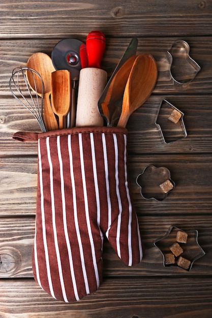 Photo ensemble d'ustensiles de cuisine en mitaine sur fond de planches de bois