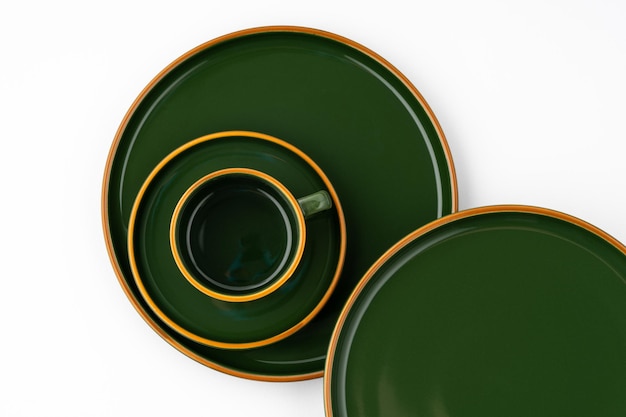 Un ensemble de vaisselle en céramique vert foncé avec des contours orange