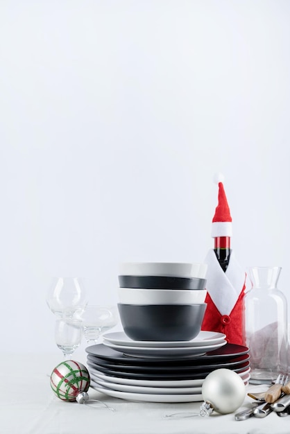 Ensemble de vaisselle en noir et blanc avec assiettes couverts et verres avec décorations de vacances sur l'espace de copie de la table à manger