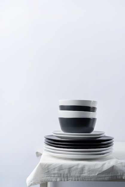 Ensemble de vaisselle en noir et blanc avec assiettes couverts et verres avec décorations de vacances sur l'espace de copie de la table à manger