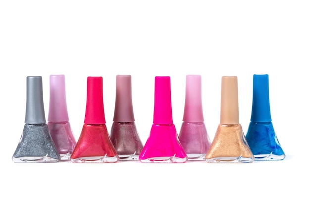 Un ensemble de vernis à ongles de différentes couleurs dans des bouteilles en verre isolé sur fond blanc