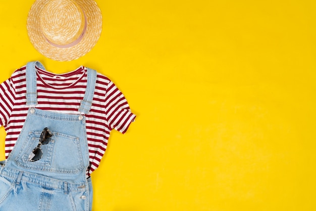 Ensemble de vêtements féminins et accessoires sur fond jaune vif