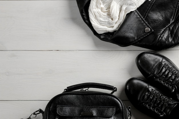 Ensemble de vêtements pour femmes noires élégantes sur fond en bois blanc.