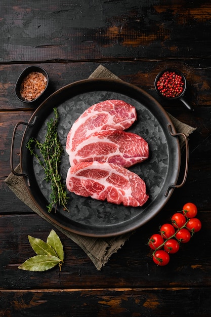 Ensemble de viande de cou de porc cru frais, sur fond de table en bois foncé ancien, vue de dessus à plat