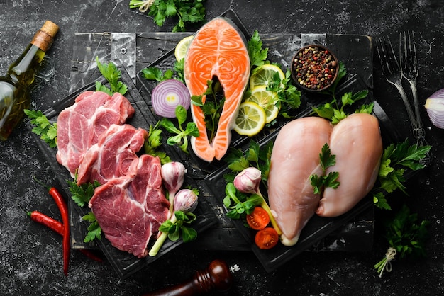 Ensemble de viande Steak de poisson steak de veau et poitrine de poulet Vue de dessus Sur un fond de pierre noire