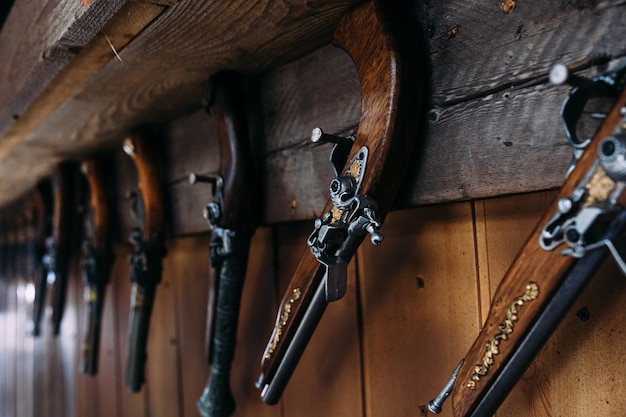 Un ensemble de vieux pistolets sur l'étagère d'une boutique de cadeaux armes médiévales