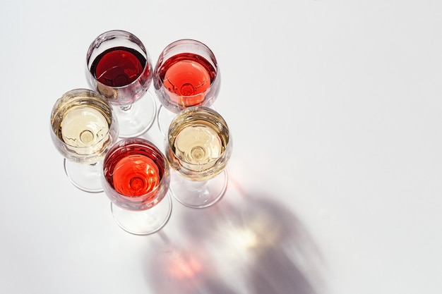 Ensemble de vin dans des verres Rose rouge et vin blanc sur table lumineuse Vue d'en haut