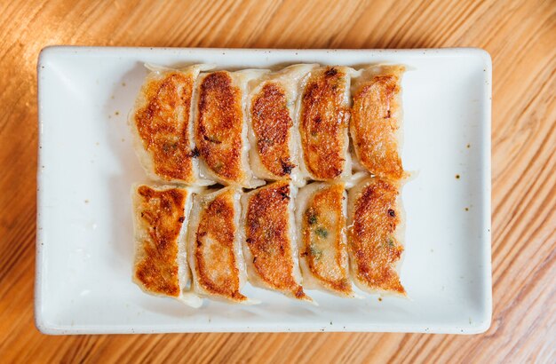 Ensemble Yaki-Gyoza (Dumplings japonais) servi sur une assiette blanche.