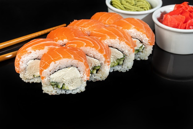 Ensembles de sushis Uramaki Californie Philadelphie roule sur une assiette blanche Menu pour restaurants cafés Sur un fond réfléchissant sombre copiez l'espace