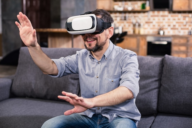Enthousiaste bel homme portant un casque et testant les technologies VR