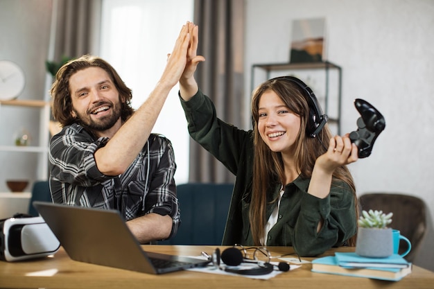 Enthousiaste couple d'amis garçon et fille se donnant un high five tout en célébrant le succès