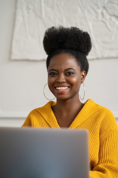 Enthousiaste femme africaine travaillant à distance sur ordinateur portable