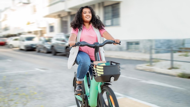 Enthousiaste femme latine en surpoids faisant du vélo en profitant de la balade à l'extérieur