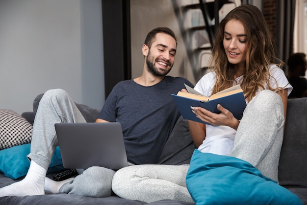 Enthousiaste jeune couple reposant sur le canapé à la maison