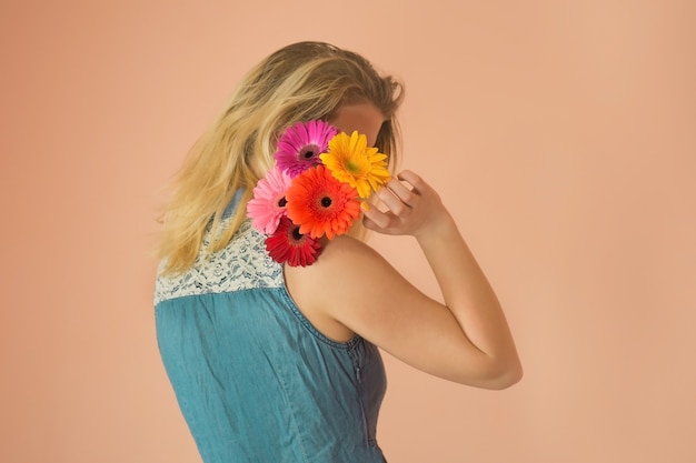 Enthousiaste jeune femme et fleurs de camomille dans les mains. Belle jolie dame debout avec bouguet de camomille.