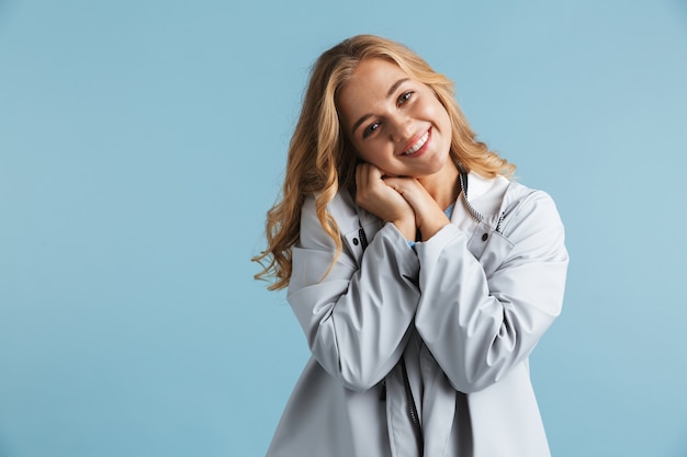 Enthousiaste jeune fille portant un imperméable debout