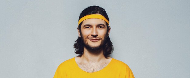 Enthousiaste jeune homme en jaune sur fond gris Vue panoramique de la bannière