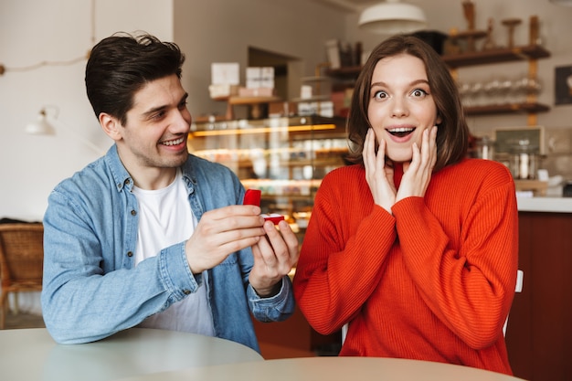 Enthousiaste jeune homme proposant à une femme