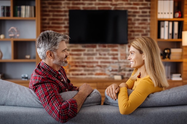 Enthousiaste mature caucasien femme et homme se détendre en regardant la télévision avec un écran vide et profiter du temps libre