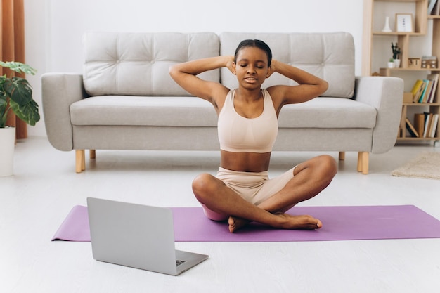 Entraînement domestique. Jeune femme noire sportive faisant de l'exercice de planche à la maison, s'entraînant dans le salon