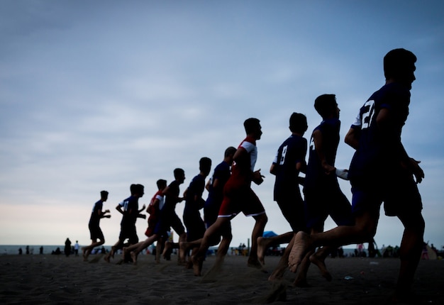 Entraînement de l&#39;équipe de jeunes garçons sur la plage du coucher du soleil