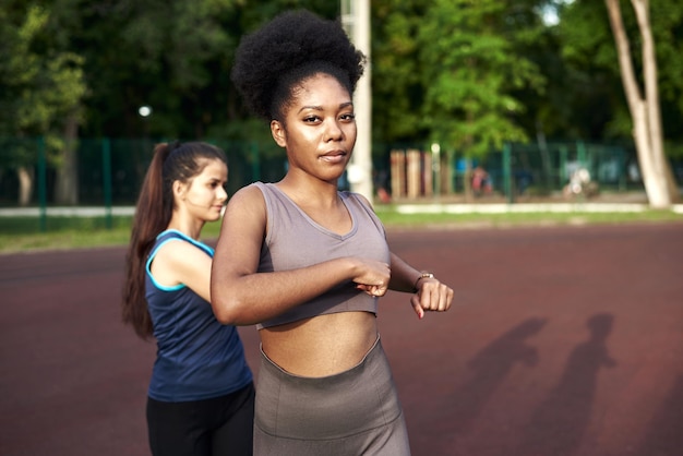 Entraînement étirant les muscles à l'air frais Deux belles femmes de fitness faisant des exercices d'étirement en étirant leurs bras Concept de forme physique et de style de vie