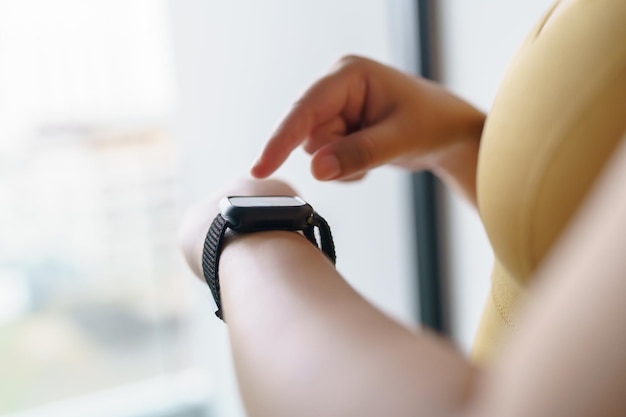 Entraînement femme avec application santé sur montre intelligente mains Gros plan