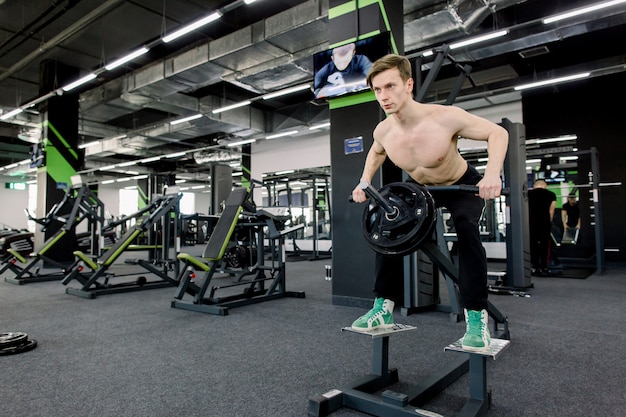 Entraînement de gym. Homme musclé travaillant dans une salle de sport faisant des exercices au triceps, torse nu masculin fort abs.