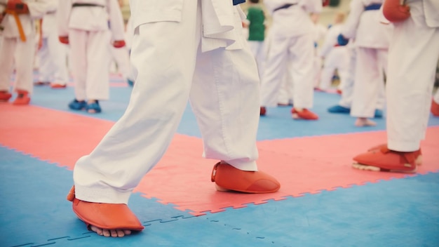 Entraînement de karaté - groupe d'adolescents de karatéka en chaussures rouges et kimono blanc, gros plan