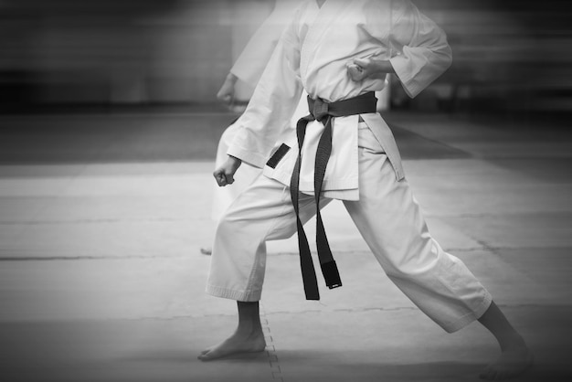 Photo entraînement karatedo et mode de vie sain ajout d'un effet de flou pour plus d'effet de mouvement style rétro avec imitation de grain de film noir et blanc