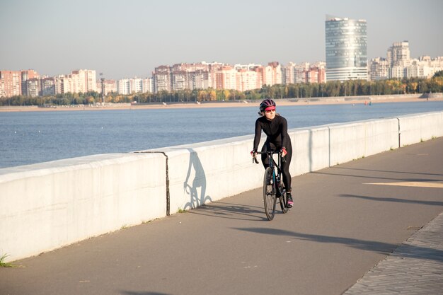 Entraînement matinal d'un cycliste sur le remblai de la ville