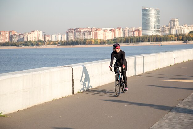 Entraînement matinal d'un cycliste sur le remblai de la ville