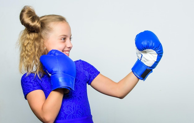 Entraînement de mode sport et vêtements de sport avec entraîneur Fight Boxer séance d'entraînement pour enfants remise en forme saine KO et énergie Succès sportif petite fille dans des gants de boxe poinçonnage Né pour se battre