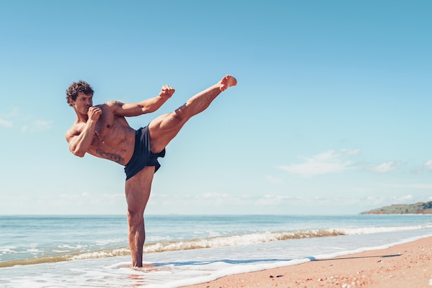 Un entraînement de muay thai ou de kickboxer avec shadow boxing en plein air au bord de la mer