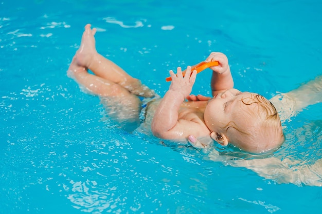 Entraînement d'un nouveau-né dans une piscine Une piscine pour bébés Développement de l'enfant Un petit enfant apprend à nager dans la piscine