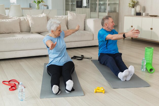 Entraînement physique entraînement senior adulte mature en bonne santé couple faisant de l'exercice sportif sur un tapis de yoga sur